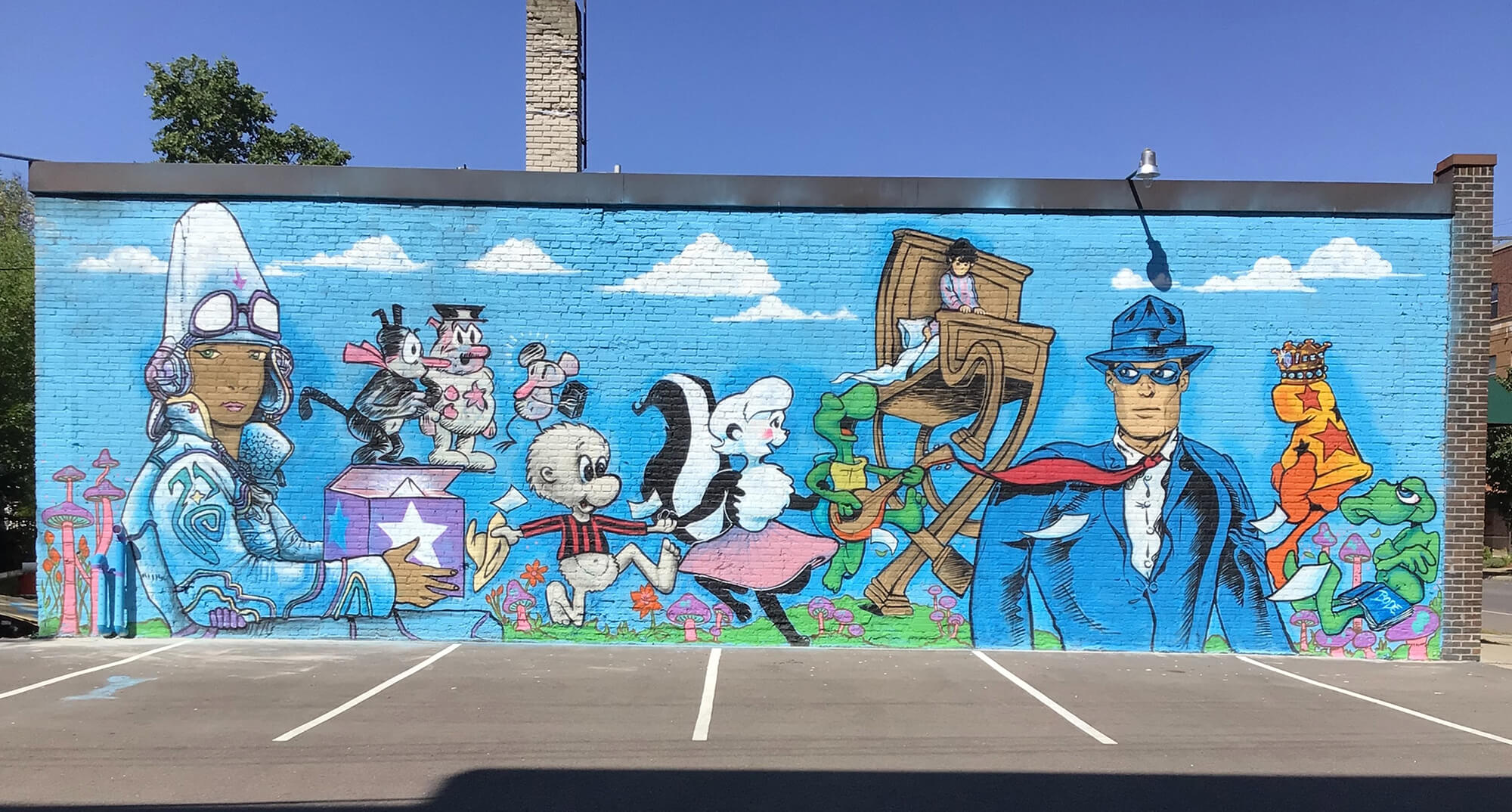 painted mural on the side of a brick building featuring famous comic book characters in a variety of art styles